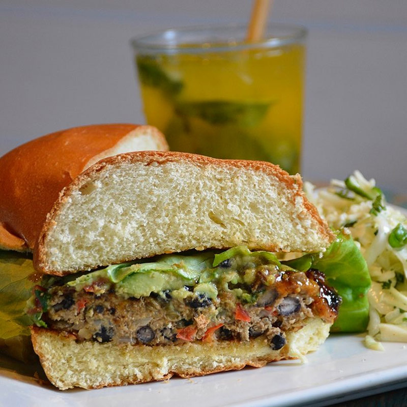 Veggie Burger with Slaw, along with a mojito, on the dine-in menu at RHUM!
